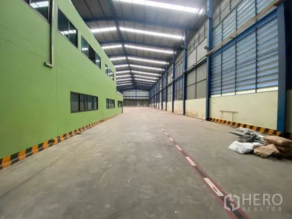 货栈 出租在Lat Lum Kaeo, Pathum Thani - 仓库内部空间宽敞，高钢结构屋顶，侧面带窗的办公区。