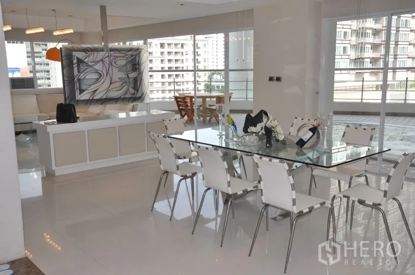 Condominium for rent in Khlong Toei, Bangkok - Modern dining area with glass table for eight, floor‑to‑ceiling windows and access to the wraparound terrace.