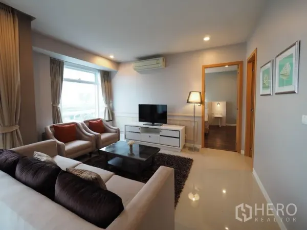 คอนโด ให้เช่าในRatchathewi, Bangkok - ห้องนั่งเล่นอบอุ่นพร้อมชั้นวางทีวี โคมไฟตั้งพื้น และเครื่องปรับอากาศ เชื่อมต่อไปยังห้องนอน