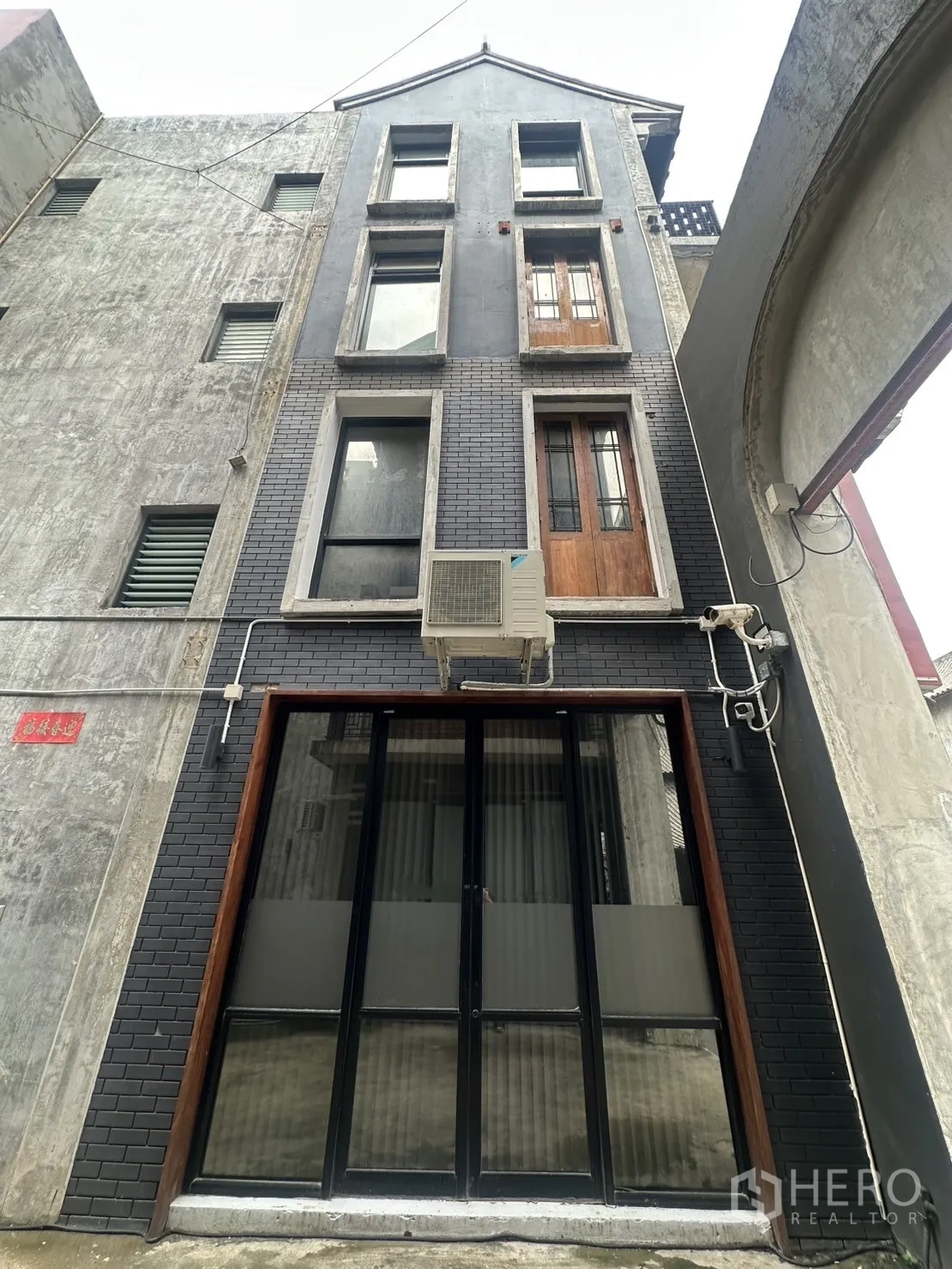 带办公室的家 出租在Pathum Wan, Bangkok - 灰砖立面带高窗，空调机位在黑框入口上方
