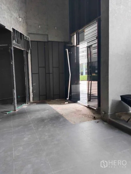 Retail Space for rent in Watthana, Bangkok - Double-height entry of a retail space opening to an outdoor plaza with gray tiles.