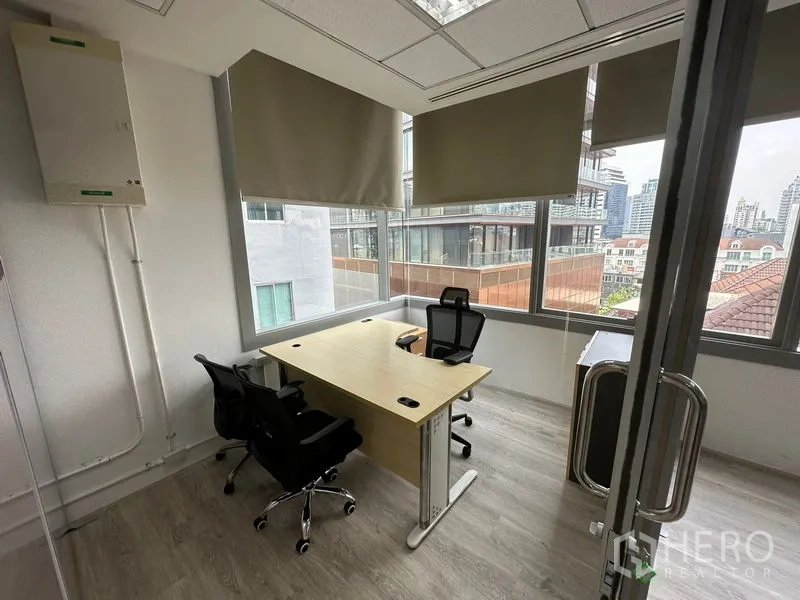 Office Space for rent in Khlong Toei, Bangkok - Private corner office with desk and chairs, featuring large windows and city views.