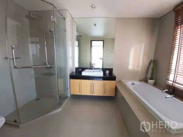 Condominium for rent in Watthana, Bangkok - Spacious bathroom featuring a glass shower, bathtub, and large mirror vanity.