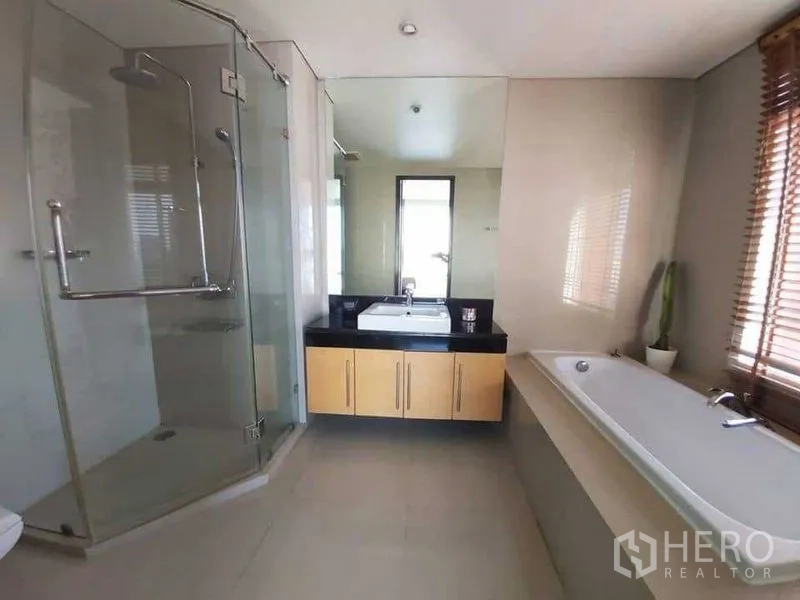 Condominium for rent in Watthana, Bangkok - Spacious bathroom featuring a glass shower, bathtub, and large mirror vanity.