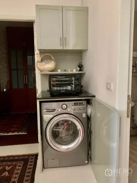 公寓 出租在Bang Kapi, Bangkok - 紧凑洗衣角，前置滚筒洗衣机、吊柜与台面小家电。