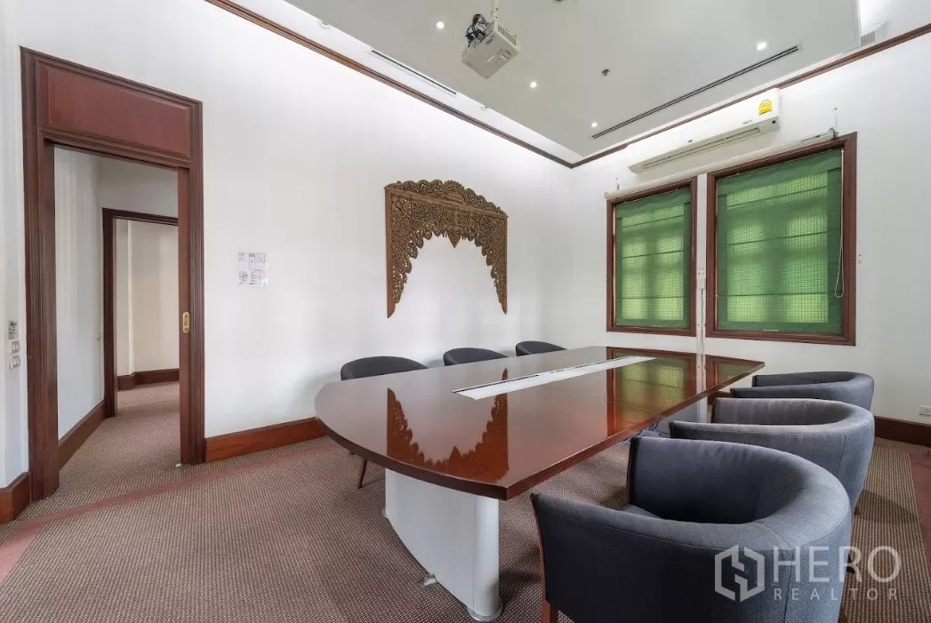 Retail Space for rent in Bang Rak, Bangkok - Meeting room with oval conference table, green blinds and carved wall art