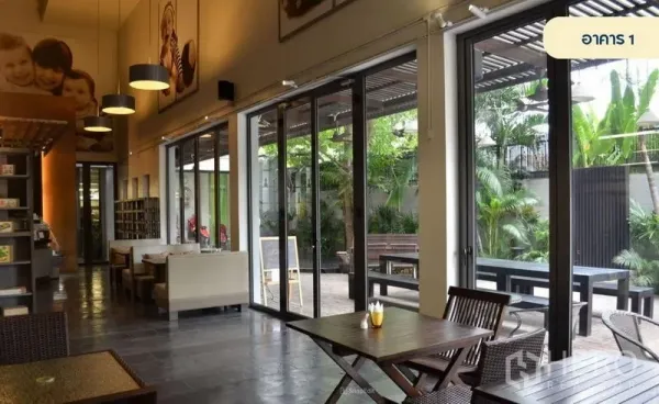 พื้นที่ขายปลีก ให้เช่าในWang Thonglang, Bangkok - โชว์รูมเพดานสูง บรรยากาศคาเฟ่ โต๊ะนั่ง และประตูกระจกบานเลื่อนเปิดสู่ลาน