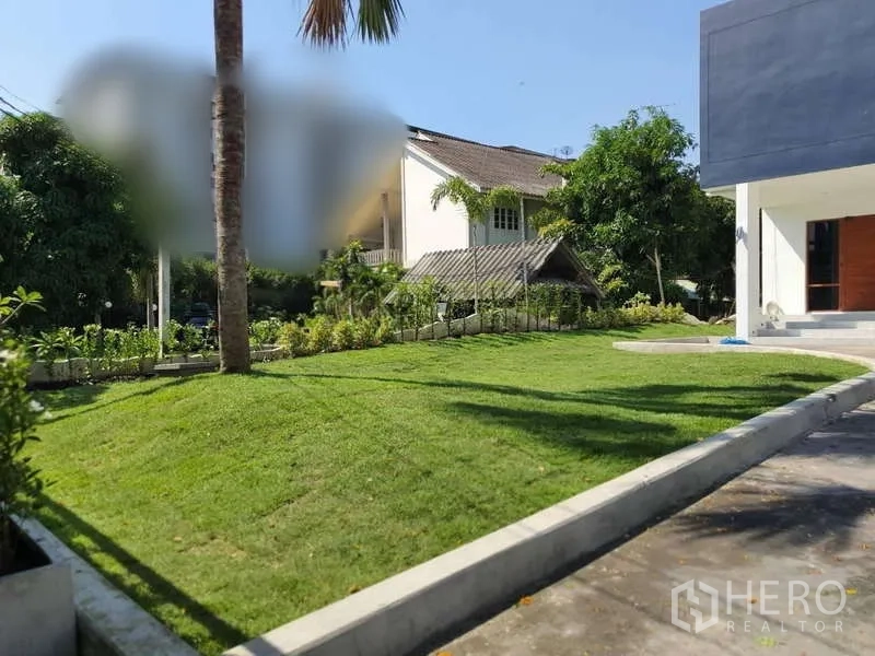 Detached House for rent in Phra Khanong, Bangkok - Front garden with trimmed grass, a palm tree and the modern facade.
