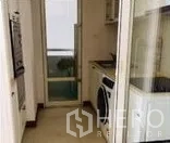 Condominium for rent in Watthana, Bangkok - Compact enclosed kitchen with white cabinetry, washer and sliding glass door to balcony.