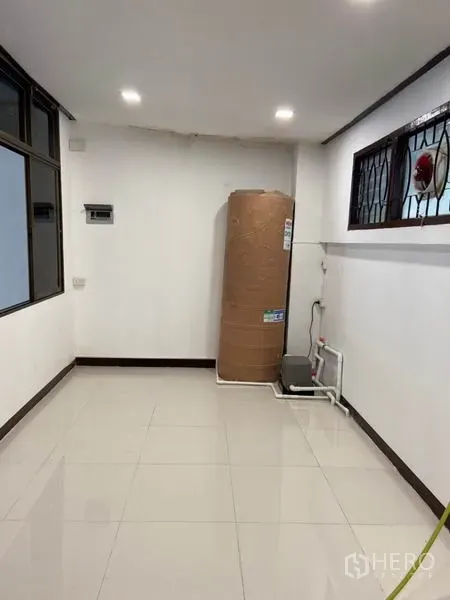 联排别墅 出租在Khlong Toei, Bangkok - 杂物/功能区，白色地砖，角落放置大型水箱与水泵，配防护窗。