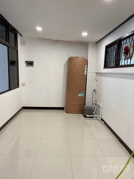 联排别墅 出租在Khlong Toei, Bangkok - 杂物/功能区，白色地砖，角落放置大型水箱与水泵，配防护窗。
