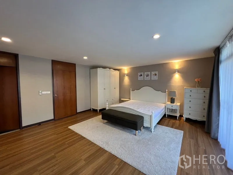 Townhouse for rent or sale in Suan Luang, Bangkok - Master bedroom with white furniture, area rug and recessed lighting.