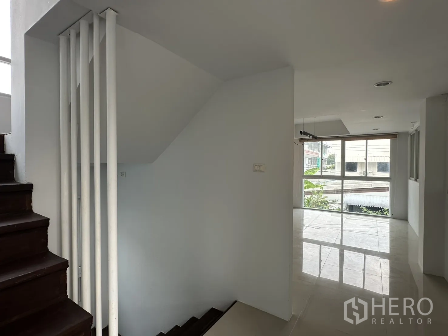 โฮมออฟฟิศ for rent in Watthana, Bangkok - ชานบันไดเชื่อมสู่พื้นที่นั่งเล่นสว่างโปร่ง หน้าต่างบานใหญ่ พื้นกระเบื้องเงา