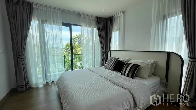 บ้าน ให้เช่าในBang Phli, Samut Prakan - ห้องนอนโปร่ง เตียงขนาดใหญ่ ม่านโปร่ง และประตูระเบียงมองเห็นสวน