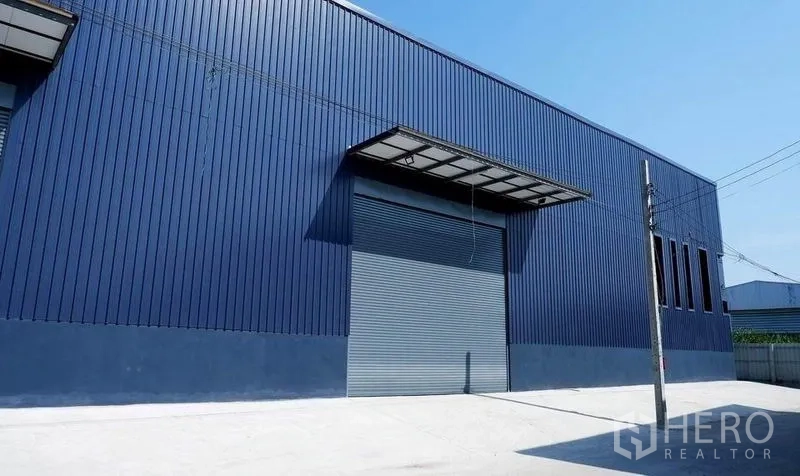 Warehouse for rent in Bueng Kum, Bangkok - Warehouse facade with a large roller shutter door and loading canopy.