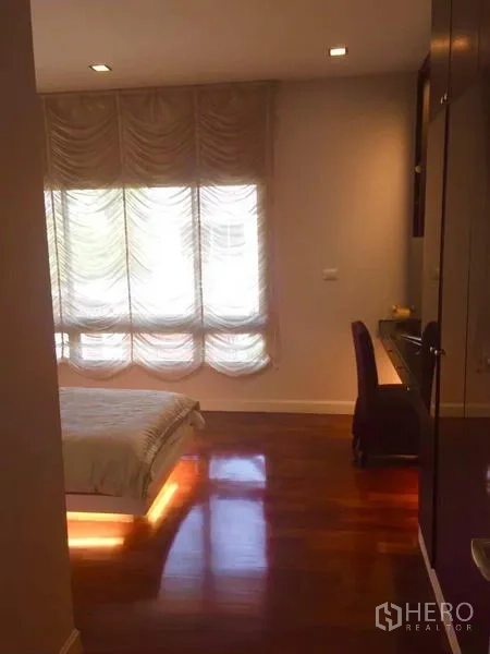 Detached House for sale in Lat Krabang, Bangkok - Cozy bedroom with draped curtains, polished wood floor and an underlit bed frame.