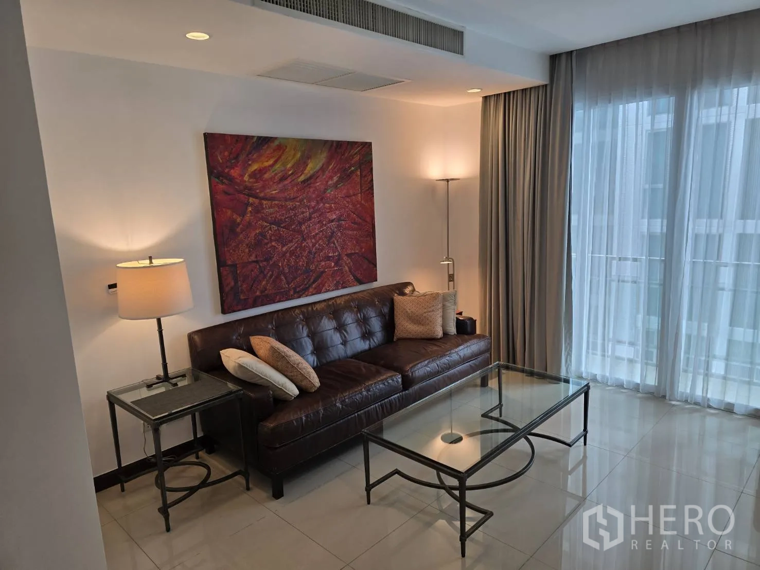 公寓 for rent or sale in Watthana, Bangkok - 客厅设电视柜与装饰画，可见厨房一角。