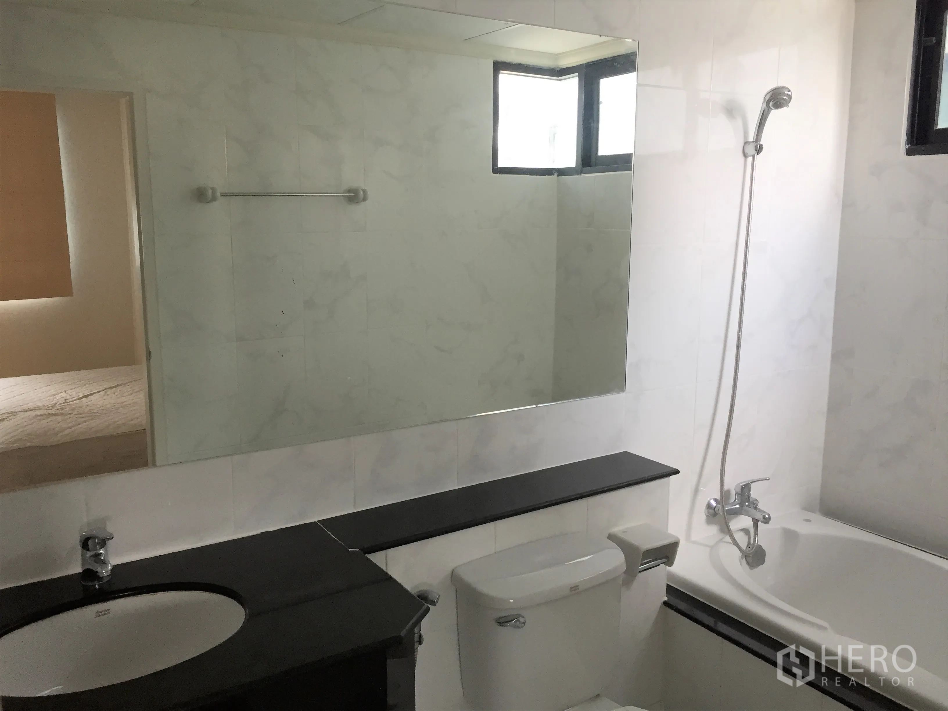 公寓 出租在Watthana, Bangkok - 浴室带大镜面，浴缸淋浴一体、马桶与深色台盆柜。
