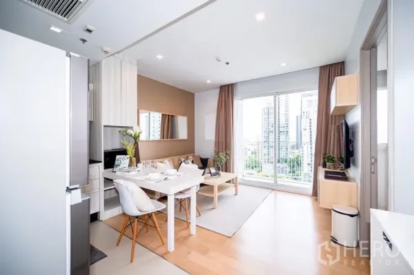 คอนโด ให้เช่าหรือขายในWatthana, Bangkok - ห้องนั่งเล่น–ทานอาหารแบบเปิดโล่ง มีครัวและประตูระเบียง มองเห็นวิวเมืองย่านทองหล่อ