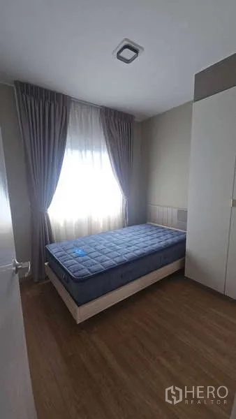Townhouse for rent in Bang Phli, Samut Prakan - Cozy secondary bedroom with single bed, wardrobe and curtained window.