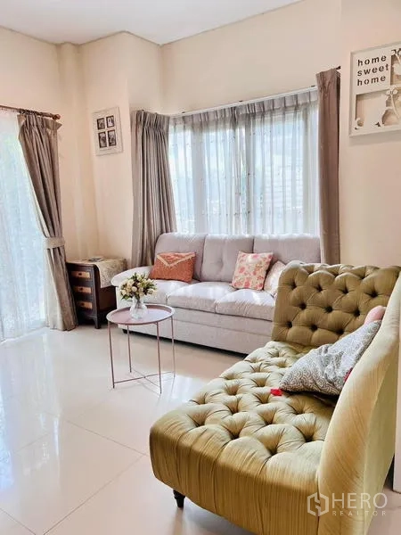 Detached House for rent - Cozy sitting corner with sofas, curtains and small table in a bright living area.