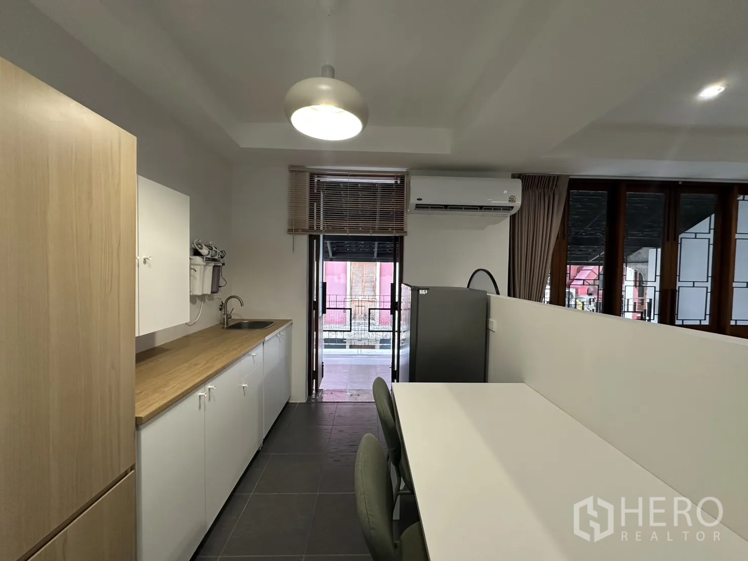 公寓 for rent in Pathum Wan, Bangkok - 厨房与用餐区，设长台面、餐桌、冰箱与空调。