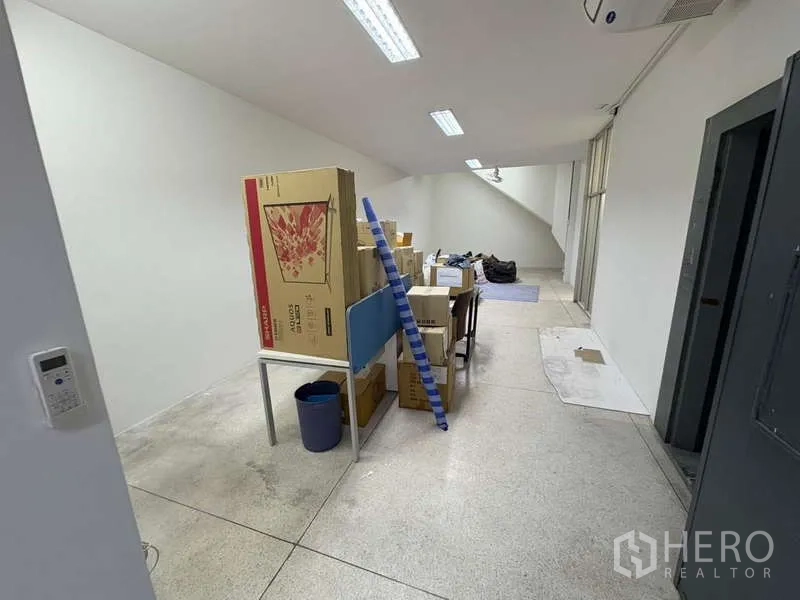 办公空间 出租在Khlong Toei, Bangkok - 储物/工作间，堆放纸箱与梯子，带高窗。
