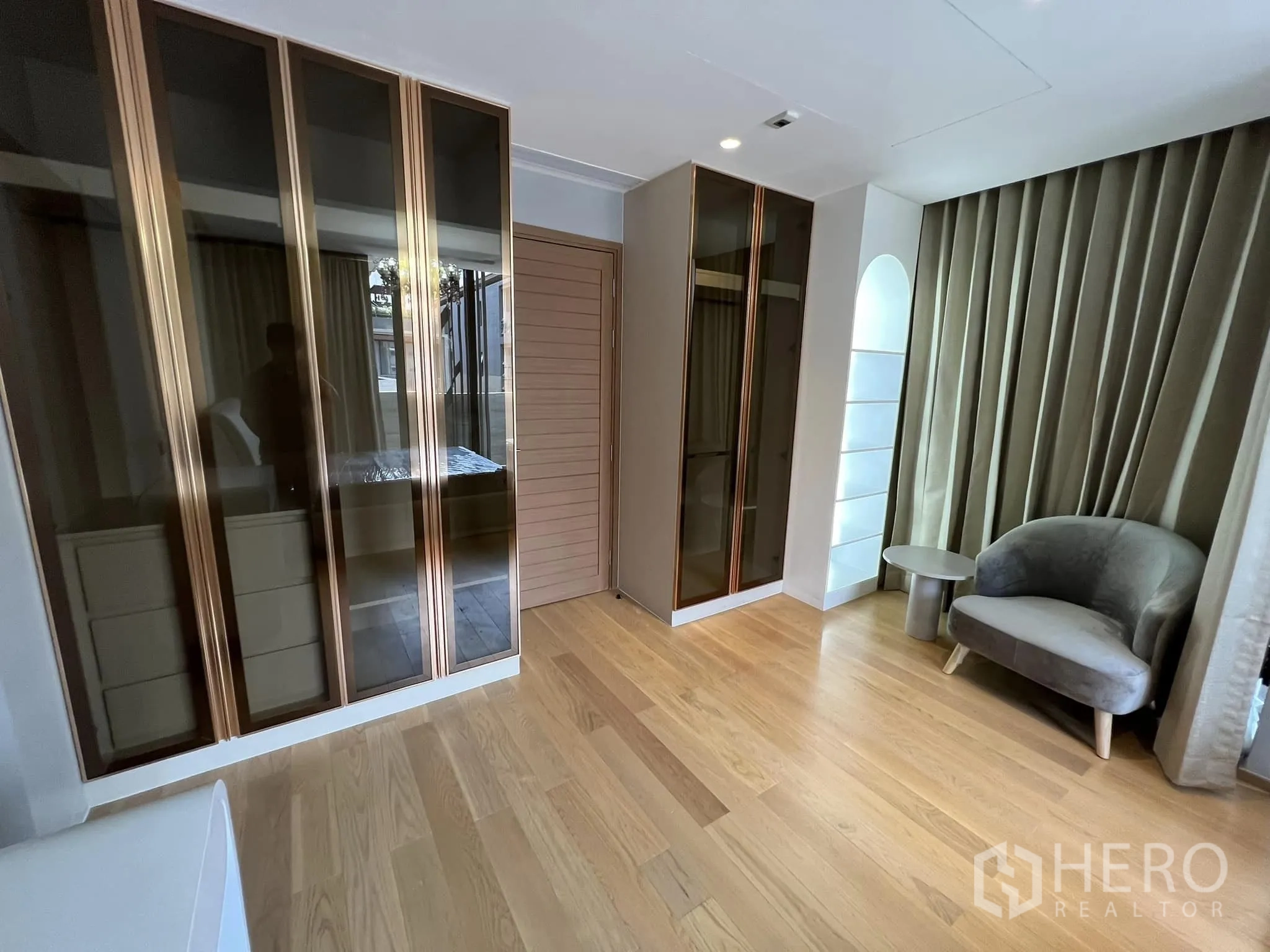 Detached House for rent or sale in Yan Nawa, Bangkok - Spacious wardrobe area with glass-front closets and lounge chair.