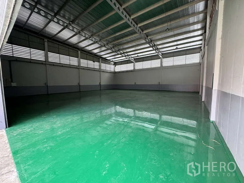 工厂 出租或出售在Lam Luk Ka, Pathum Thani - 高挑仓库内部，钢结构屋顶与亮面绿色环氧地坪。