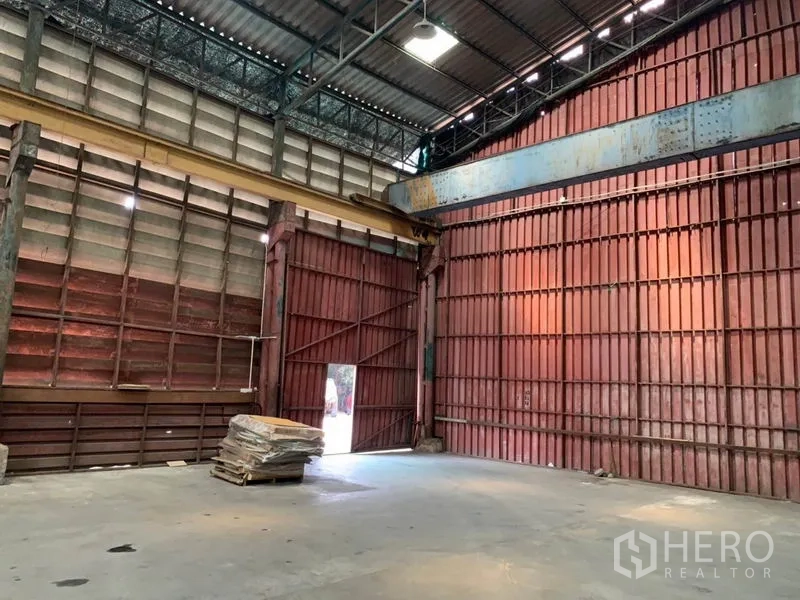 Warehouse for rent in Bang Kho Laem, Bangkok - Large sliding metal doors providing wide loading access within the warehouse.