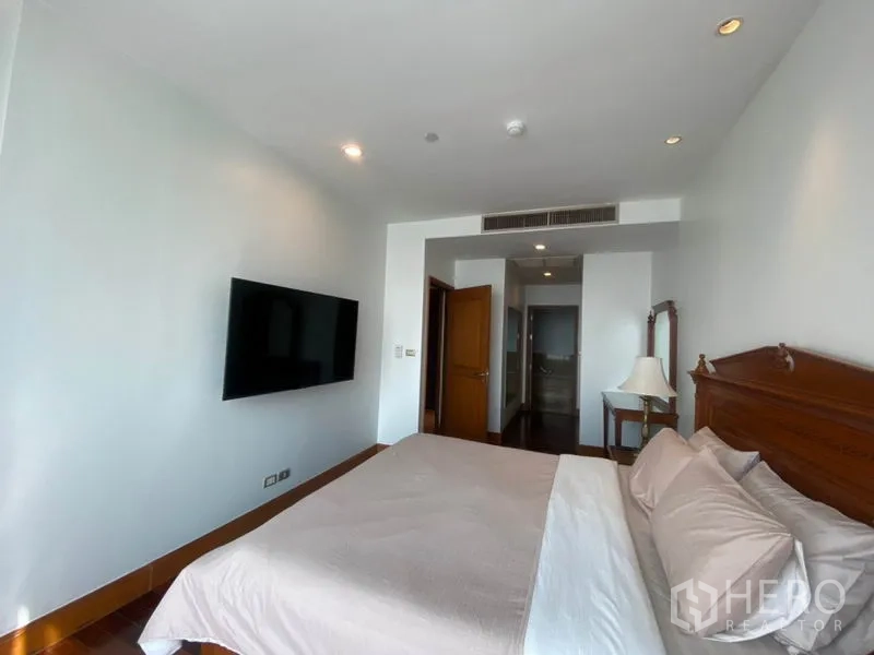 公寓 出租在Sathon, Bangkok - 主卧另一角度，墙挂电视、筒灯照明，连接更衣区域。