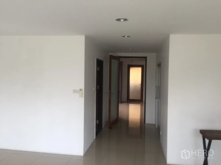 Townhouse for rent in Bang Rak, Bangkok - Bright hallway with recessed lights, white walls and glossy tile floors in a Bangkok townhouse.