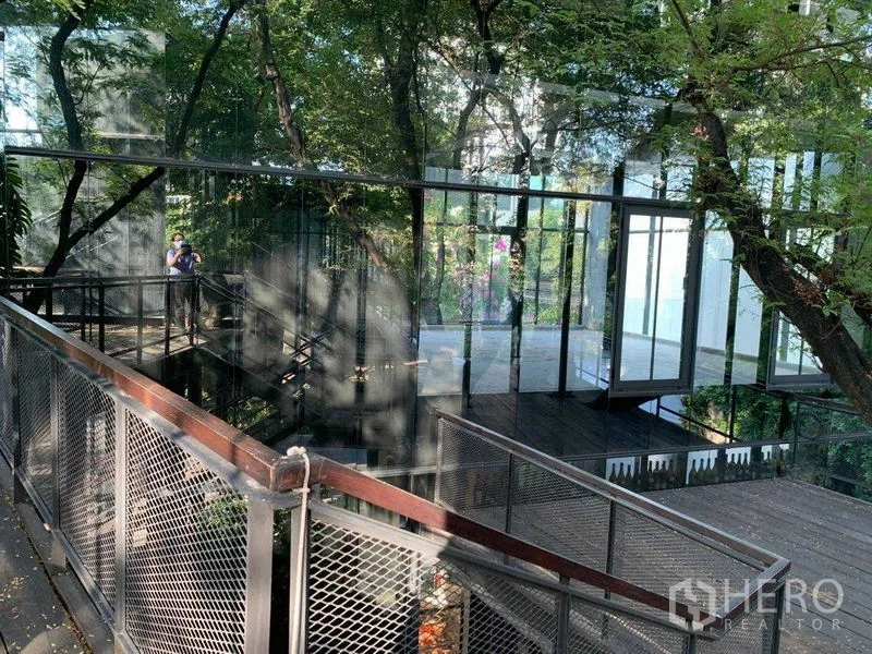 สำนักงาน ให้เช่าในKhlong Toei, Bangkok - ทางเดินโลหะยกระดับและอาคารกระจกท่ามกลางต้นไม้ใหญ่
