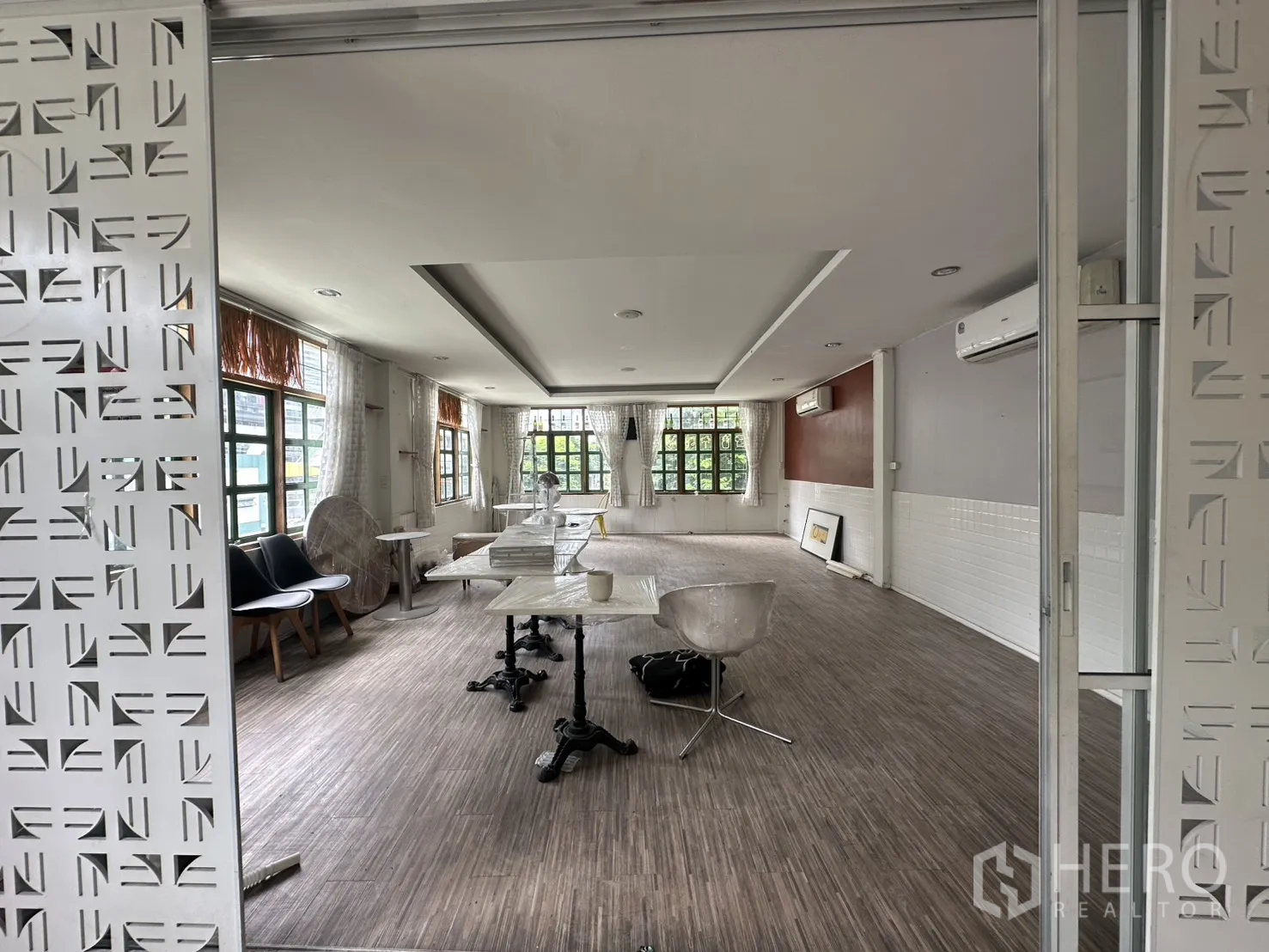 零售空间 for rent in Sathon, Bangkok - 宽敞室内，带可滑动镂空隔断、座椅、大窗与吊顶。