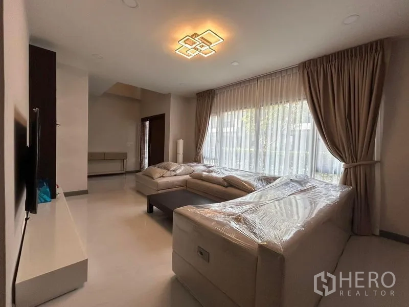Detached House for rent - Spacious living area with corner sofa, sheer curtains and modern ceiling light.