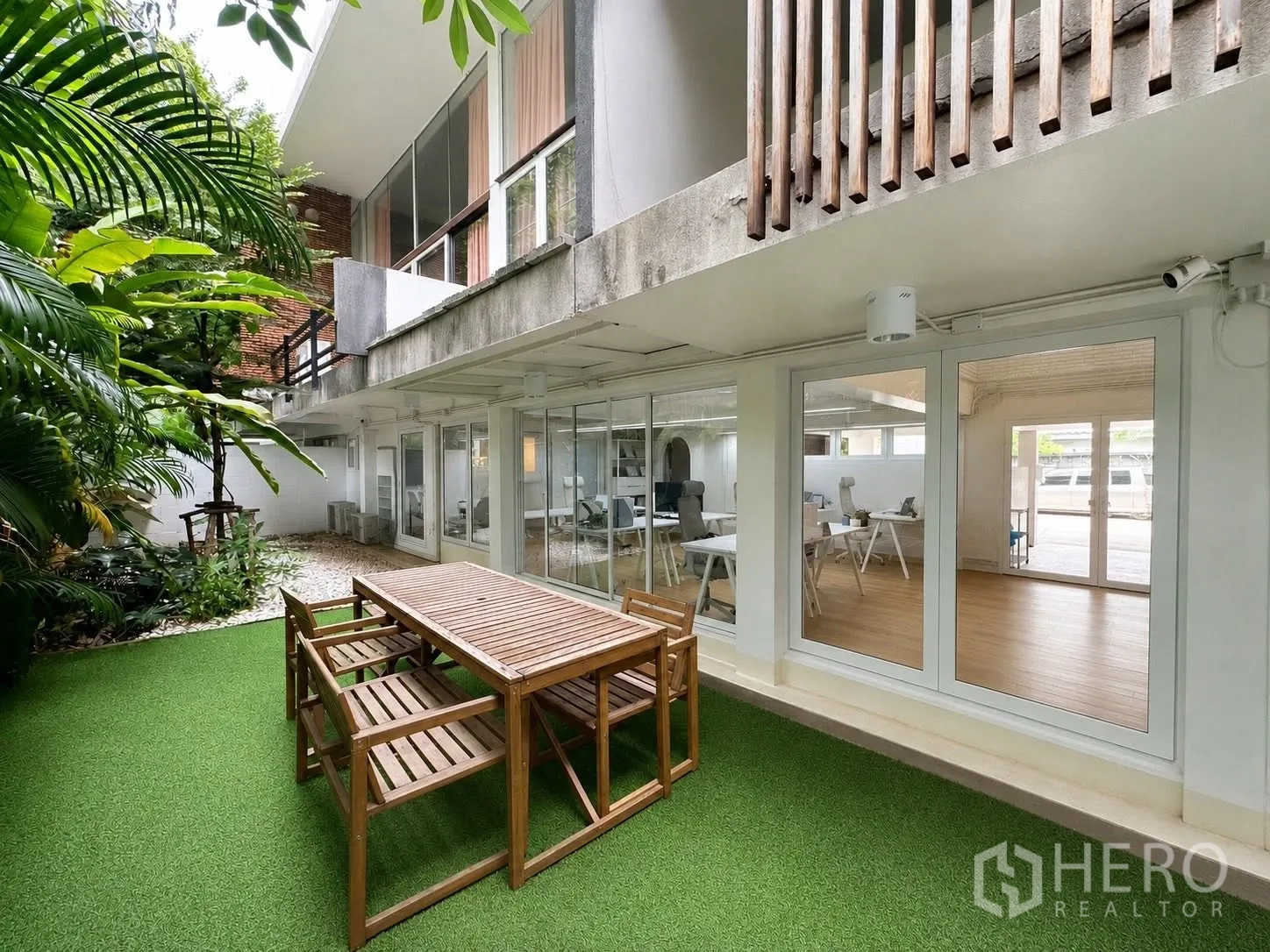 办公室 for rent in Phaya Thai, Bangkok - 花园露台设木质户外桌，旁为通向办公室的玻璃门。