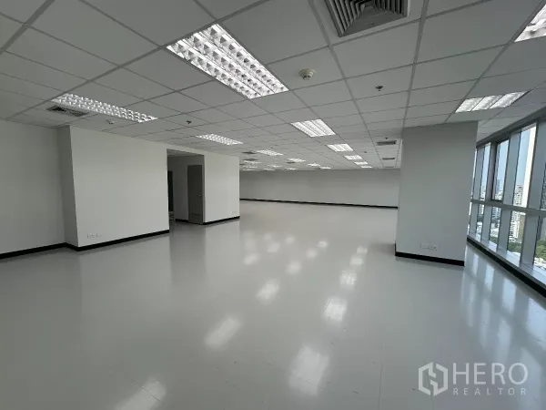 办公空间 出租在Watthana, Bangkok - 转角办公楼层，临窗面宽与立柱，通向服务区的门，自然采光充足。