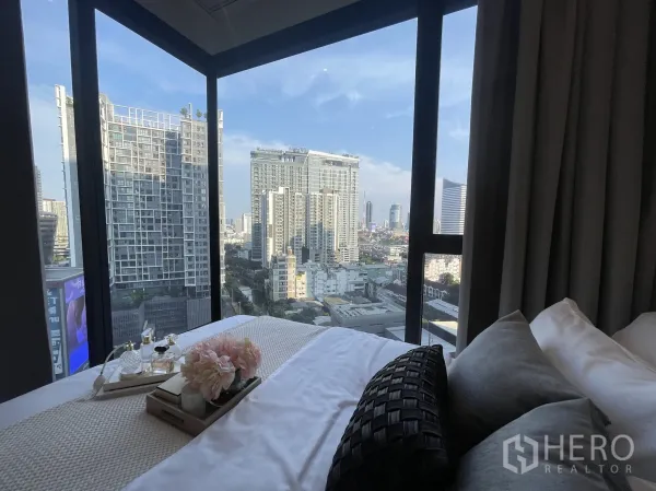公寓 出租在Din Daeng, Bangkok - 卧室转角落地窗俯瞰拉玛九区高楼城市景观。