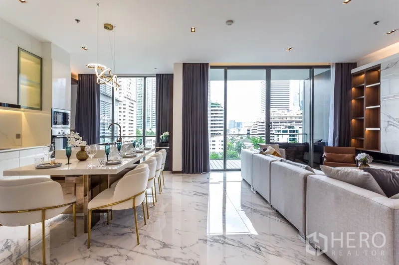 Condominium for rent in Khlong Toei, Bangkok - Open-plan living and dining leading to balcony with city views and natural light.