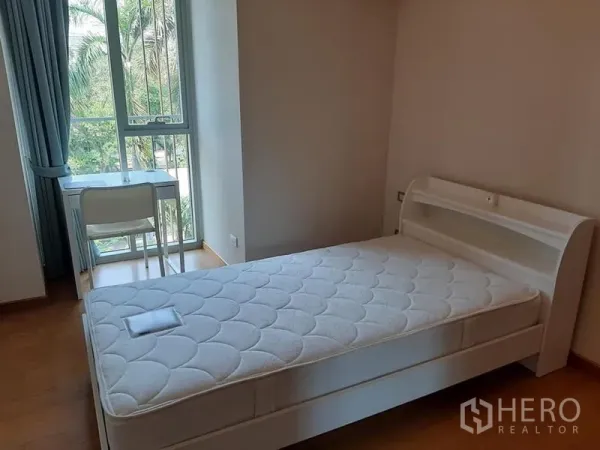 公寓 出售在Watthana, Bangkok - 次卧配白色床与书桌，落地窗享花园景。
