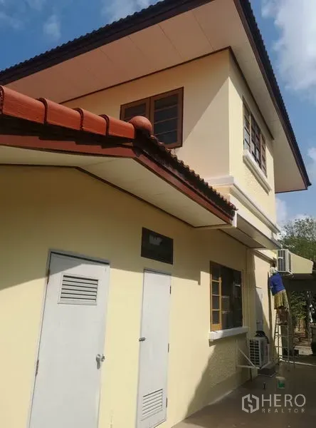Detached House for sale - Side exterior of a cream two-storey house with tiled eaves and utility doors.