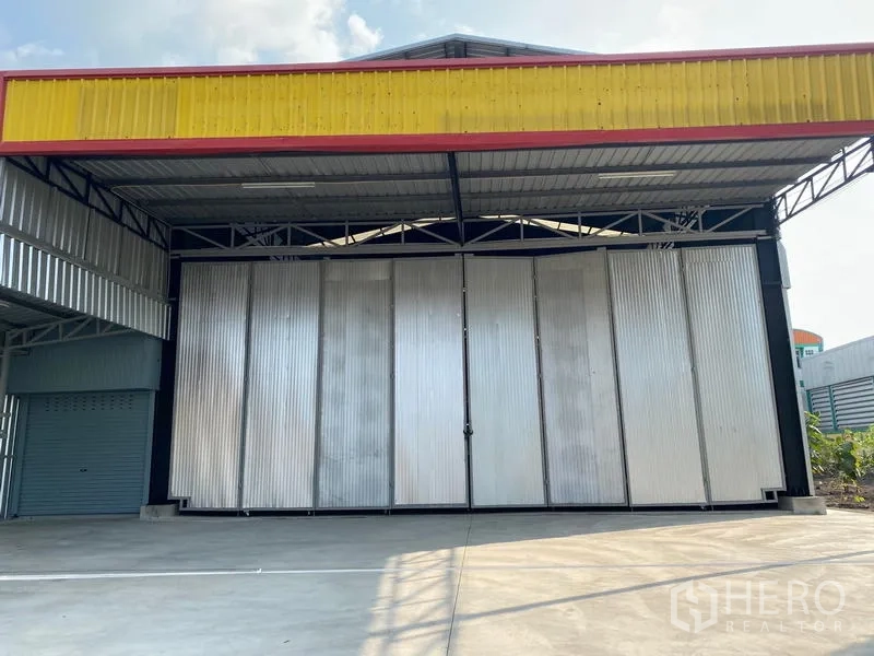 Warehouse for rent in Lat Krabang, Bangkok - Covered truck access and oversized gate at the warehouse entrance with private parking area.