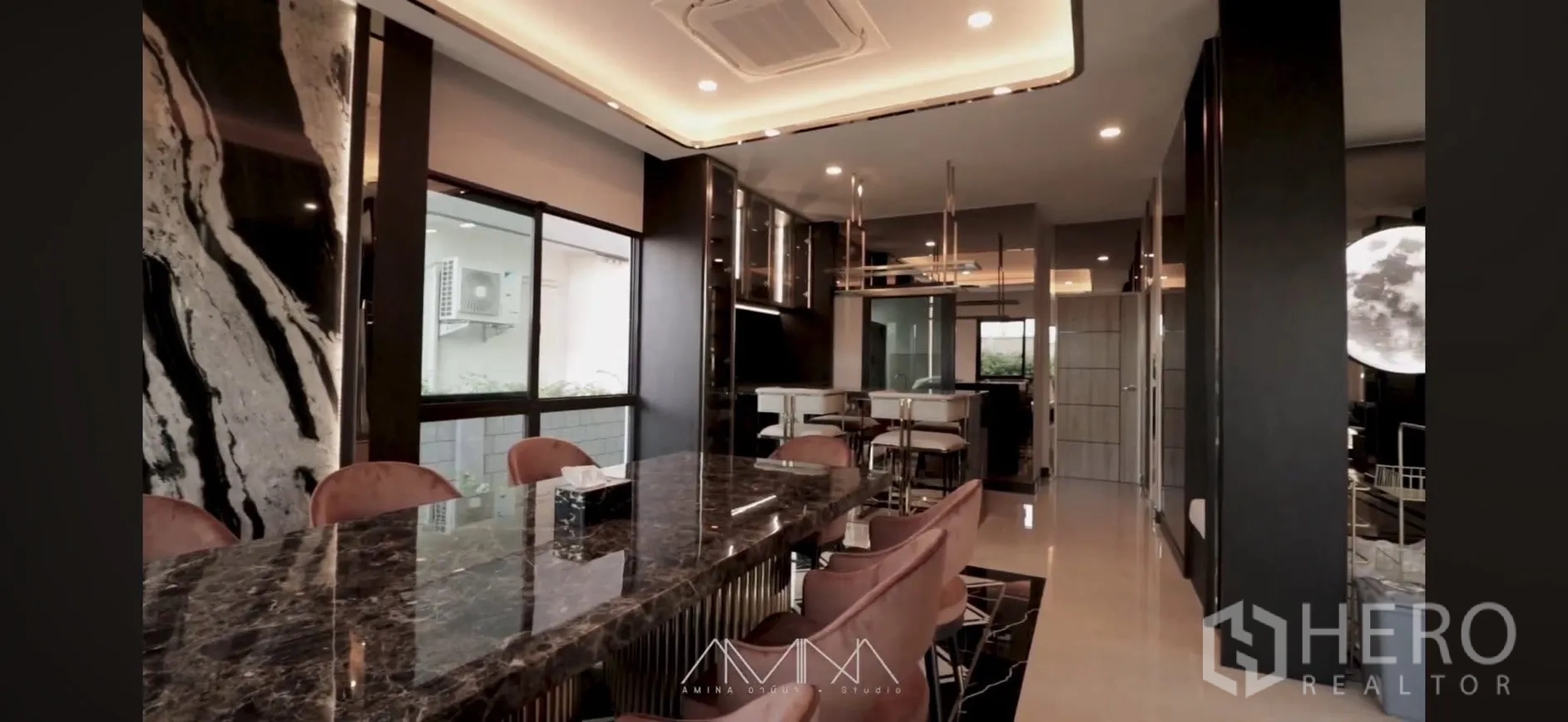 Detached House for rent in Saphan Sung, Bangkok - Dining area with long marble table, upholstered chairs, and recessed lighting.