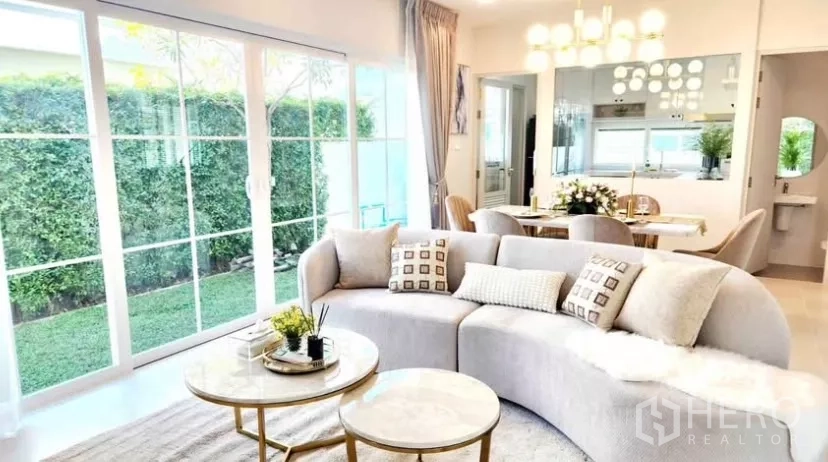 独立式住宅 出租在Bang Phli, Samut Prakan - 开放式客餐厅，落地推拉门面向花园。