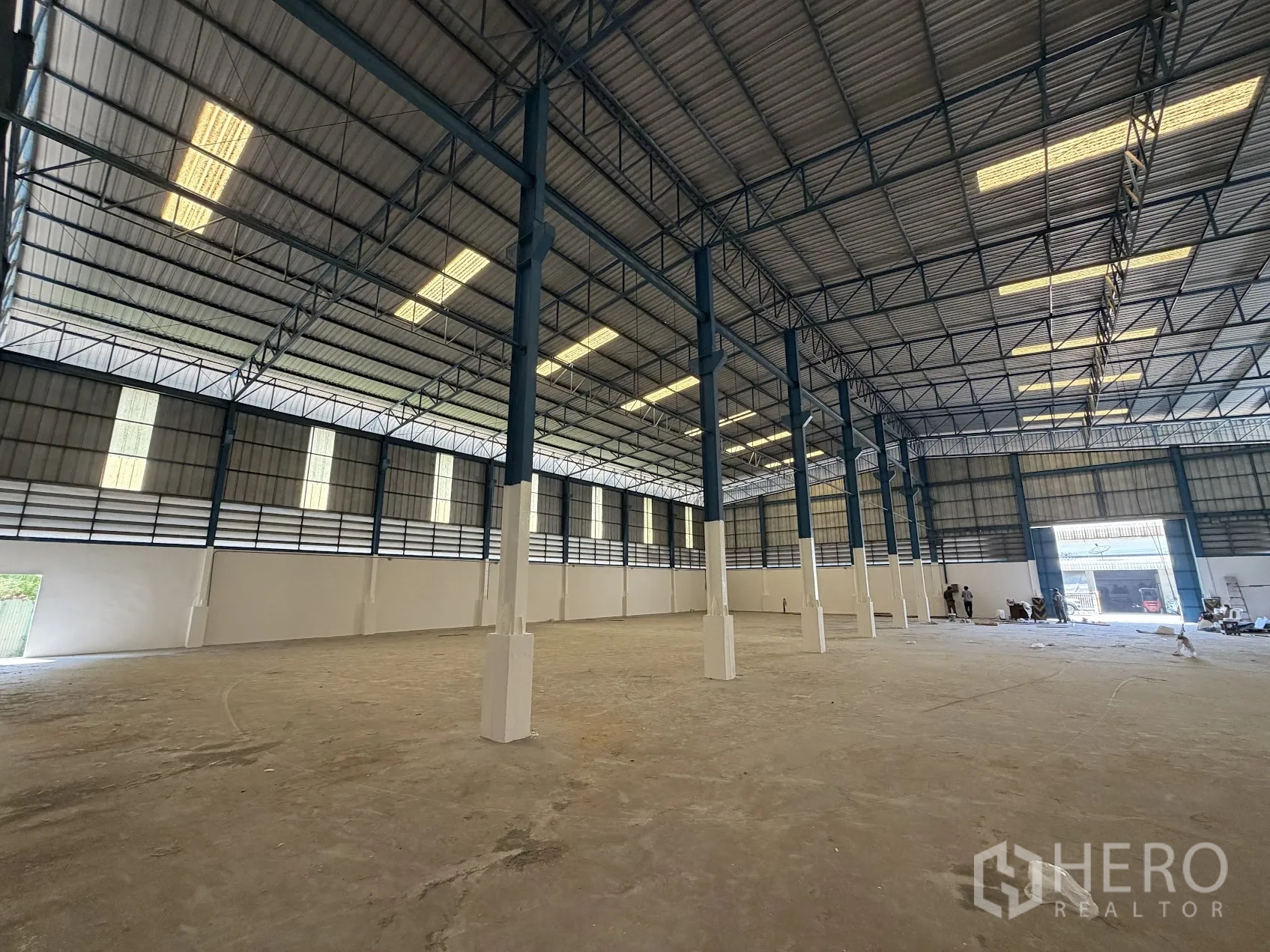 โรงงาน for rent in Bang Sao Thong, Samut Prakan - ภายในคลังสินค้าเพดานสูง โครงถักเหล็ก เสาตั้งสูง และแผ่นหลังคาโปร่งแสงให้แสงสว่าง