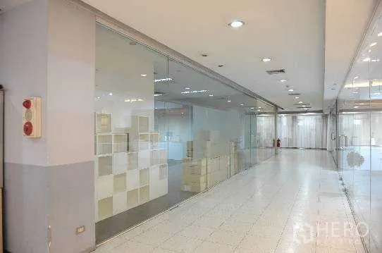 办公空间 出租在Khlong Toei, Bangkok - 转角视角的玻璃幕墙办公室外观与明亮走廊。