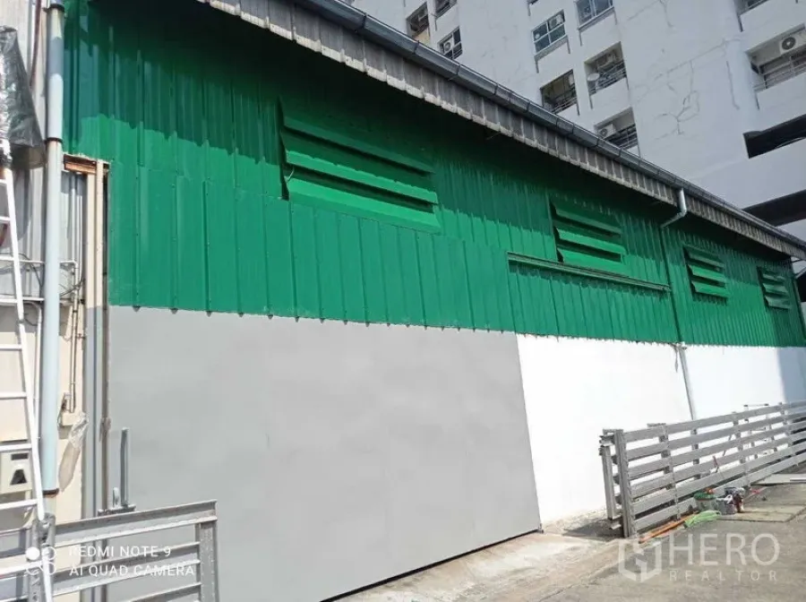 货栈 出租在Suan Luang, Bangkok - 绿白金属外墙的仓库外立面，带百叶通风口和围栏