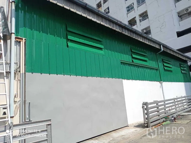货栈 出租在Suan Luang, Bangkok - 绿白金属外墙的仓库外立面，带百叶通风口和围栏
