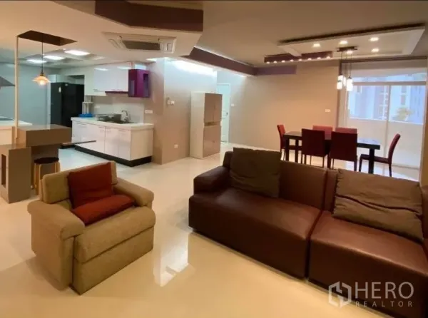 公寓 出租在Watthana, Bangkok - 开放式起居区，沙发区连通窗边餐桌与现代厨房