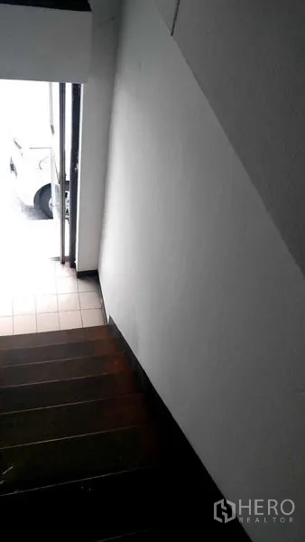 Retail Space for rent in Bang Rak, Bangkok - Staircase descending to an entrance with daylight at the doorway, showing tiled flooring near the front.